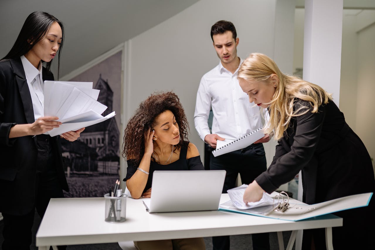 4 employees filing papers and stressed